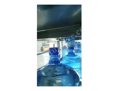 Машина для установки защитной ленты на крышку бутылки с водой